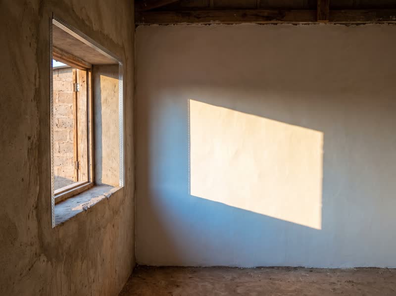 Mur fraîchement enduit, lissé, dans la lumière rasante
